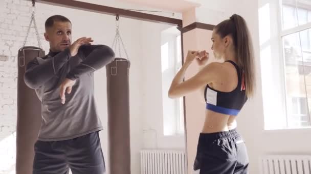 Cute girl uczy się technik kickboxing w siłowni z doświadczonym trenerem — Wideo stockowe