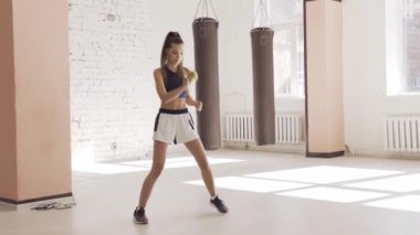 Genç bir kız, koçunun rehberliğinde koordinasyon ve hızlı tepki için koçluk görevini yerine getiriyor.