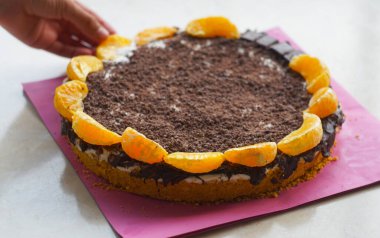                 Bir kız çikolatalı tatlının üstüne mandalina süslemiş..