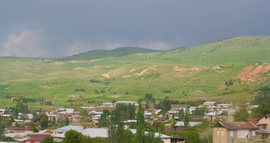                               Dağın eteklerinde büyük köy evleri görülebilir..