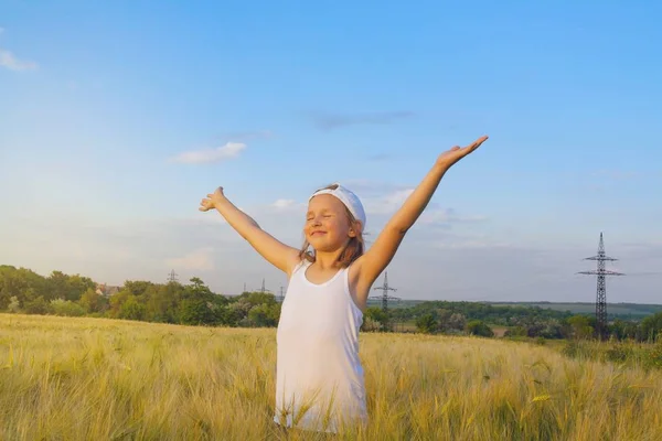 Girl playing in the sun . Loving the free . Inner world of the child . Meditation as way of life . Relaxation in the fresh air . Portrait of the happy beautiful young woman . in the field of wheat