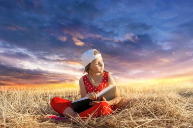 Child reading book or bible outdoors . Young Child's Hands Praying on Holy Bible .  Inner world of the child  . Relaxation in the fresh air . Portrait  clipart