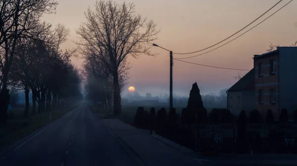 謎の村の朝 夜明けの霧の国の道路 — ストック写真