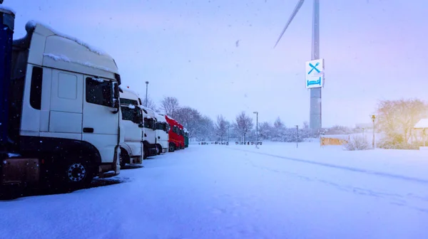 Trucks in a row . Truck on a winter road . will lock movements of trucks during bad weather