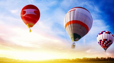 Balonlar gün batımının arka planına doğru uçar. Sıcak hava balonları