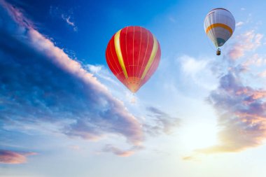 Balonlar gün batımının arka planına doğru uçar. Sıcak hava balonları