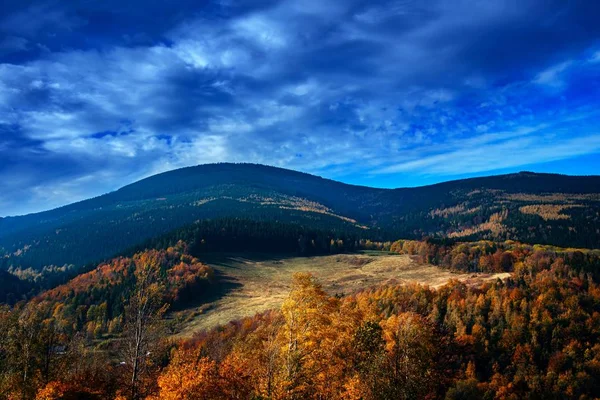 Mountains Karkonosze in Poland . Go to the target . In autumn view from mountain peaks . Amazing scene on autumn mountains. Yellow and orange trees in fantastic morning sunlight.   Scenic view of mountains and trees at autumn