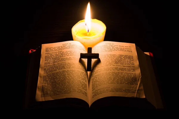 点着蜡烛和圣经 赞美诗 神圣的书 在圣经的新约中 在一个黑色的背景下 基督教十字架 — 图库照片