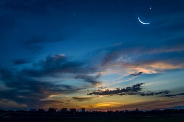 Yeni ay. Dua zamanı geldi. Cömert Ramazan. Bulutlarda gün batımı ve yeni ay. Doğanın sükuneti