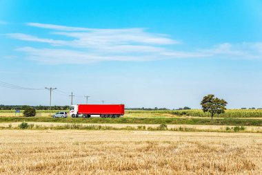 Gökyüzüne karşı kırsal yolda hızlı mesaj trafiği için geniş bir kamyon ve römork.