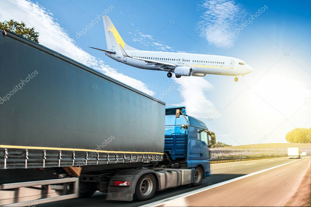 The plane is landing flying over the road with a truck