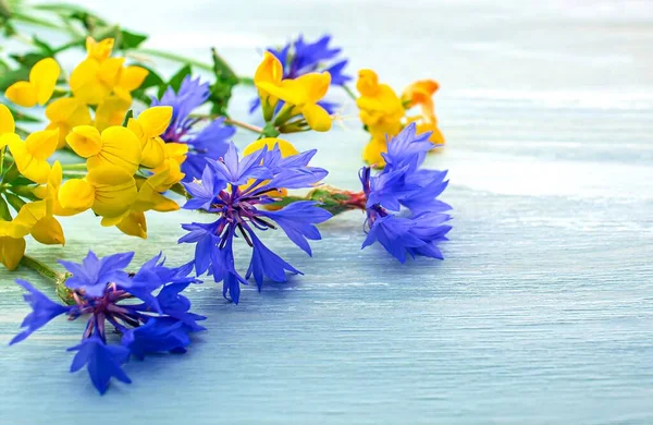 Mavi ahşap arka planda çiçek buketi, hala bir buket yabani çiçekle hayat.