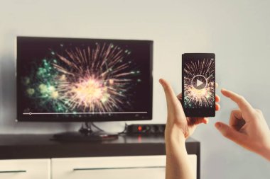 Smartphone evde Video izlerken bir TV'ye bağlı olan adam. telefondan Tv ekranına transfer video. Modern araçlar. Yere wifi cihazlar arasında bilgi aktarımı.