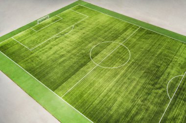 çimenlerin üzerinde çizgili bir gerçek futbol sahası. Belirli bir açıyla üstten görünüm