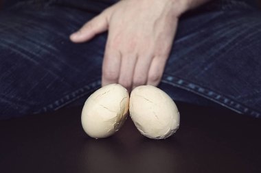 Erkeklerin testis - kasık ağrısı ve yıldırım. Erkek testisi hastalığında kavramı. Kırık yumurta erkeklerde testis sorunları sembolüsün.