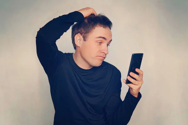 Jeune Homme Réfléchi Lit Message Sur Smartphone Noir Moderne Émotion — Photo