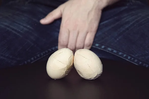 Men Testes - groin pain and lightning. The concept of disease in male testicles. Broken eggs are a symbol of problems with testicles in men. — Stock Image Men Testes Groin Pain Lightning Concept Disease Male Testicles Broken Stock Photo