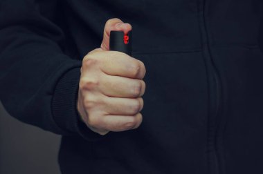 A mans biber gazı küçük bir şişe tutan el
