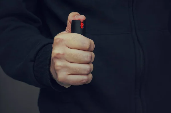 A mans hand som håller en liten flaska av pepparspray — Stockfoto