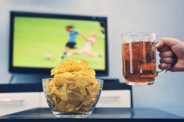 Bir Dünya Kupası futbol maçında olan ekranda büyük bir Tv arka plan üzerindeki fişlere yanındaki adam elinde bira ile bira bardağı. futbol erkek eğlence, futbol fanatik,