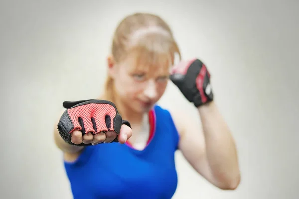 A studio shot of beautiful fitness woman training boxing or functional exercise. The girl shows the fist. Training melee. Women\'s fight without rules. body, healthy, lifestyle,