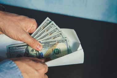 Erkekler takım elbiseli adam. Rüşvet ve yolsuzluk doları banknot ile. Sarmalayıcı para ile. Zarflarda gri maaşları. Yasadışı ücret. Vergi kaçırma işveren tarafından.
