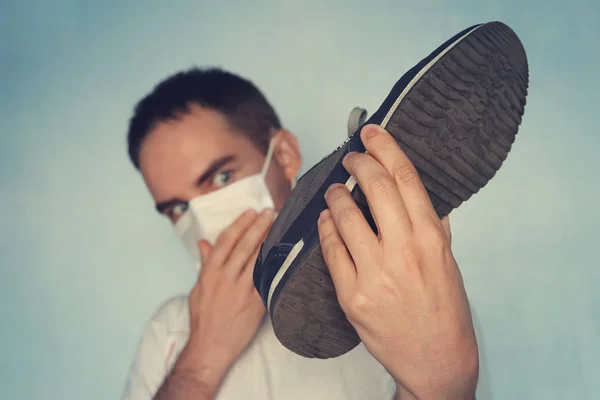 Man Met Masker Houdt Vieze Stinkende Schoen Vast Onaangenaam Geurconcept — Stockfoto