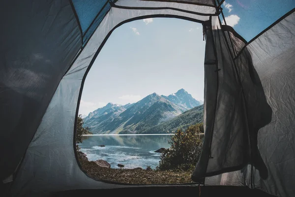 Blick vom Zelteingang auf den schönen See am Morgen. Zelten in den Bergen. schöne Aussicht aus dem Zelt. Ruhe in freier Wildbahn. Stimmungsvolles Foto — Stockfoto