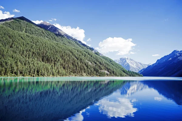 Russia ,Altai ,the mountains, the lake Kucherla. reflection of mountains with snow-capped peaks in crystal clear water