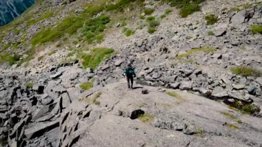Yaşam tarzı seyahat mutlu duygular kavramı açık. Ellerini güzel dağ manzarası arayan tarafa yayılan turist. adam dağ başında sevinir. drone spin, videodan döner