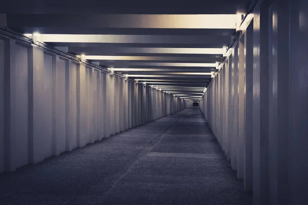 Tunnel, underjordisk övergångsställe på natten. En lång betong tunnel med lyktor i staden under jord. Vägport — Stockfoto