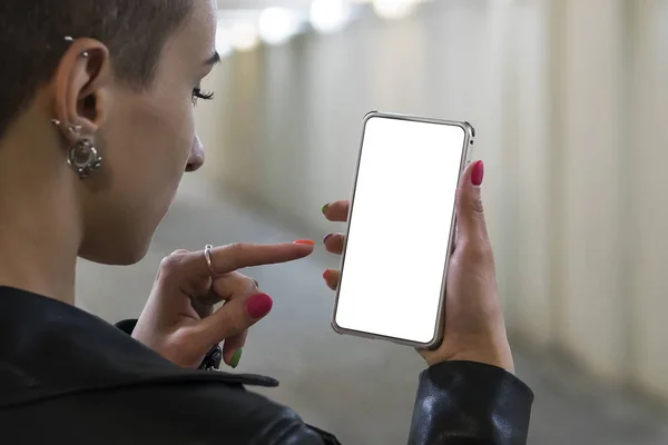 Chica sosteniendo en el teléfono inteligente con el monitor de pantalla en blanco vacío en el fondo luz bokeh en la atmósfera de la calle, hipster freelancer utilizando en manos femeninas teléfono inteligente con plantilla en blanco, desenfoque , — Foto de Stock