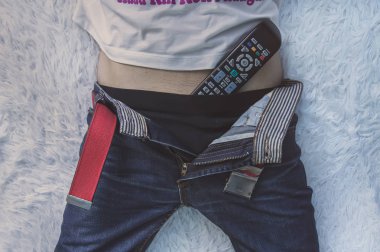 Adam yatakta yatan ve onun iç çamaşırlarıyla uzak Tv Tv izlerken.