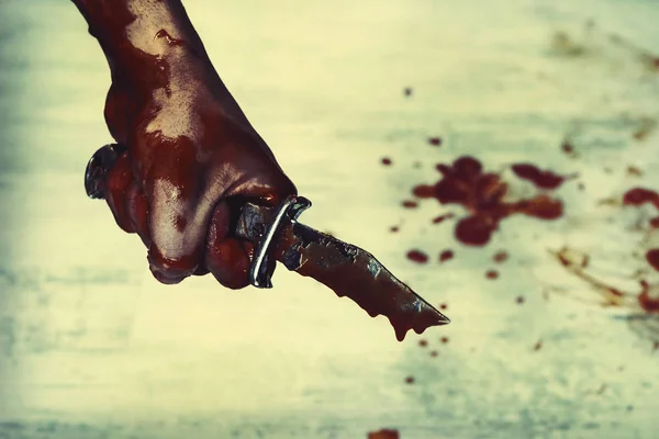 Bloody stabbing. Hand with knife knife, horror blood. Edged weapons in the hand of the Slayer.
