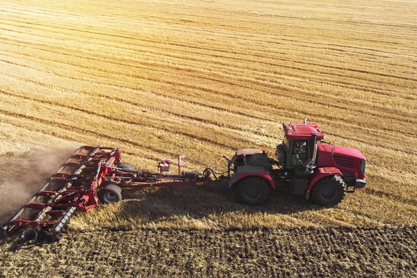 Z lotu ptaka dron pola żniw z ciągnikiem kosi suchą trawę. Jesienne żółte pole ze stogiem siana po żniwach widok z góry. Zbiory na polach. Zapasy siana na zimę. Widok z góry. — Zdjęcie stockowe