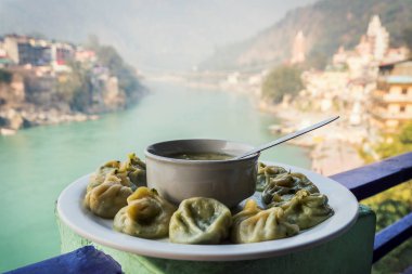 Büyük bir tabak Tibet Momo ve Ganj Nehri'nin zemin üzerine sıcak çorba. Rishikesh Hindistan., yoga şehir Hindistan, Gange Nehri Ganga Ram Jhoola Jula