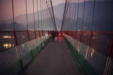 Laxman Jhula asma köprü nehir Ganga üzerinde geçiş insanlar. gece, akşam, karanlık, twilight,