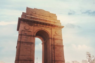 Historic India Gate Delhi - A war memorial on Rajpath road New Delhi. main Indian historical landmark in the background of the cloudy sky in the sunlight clipart