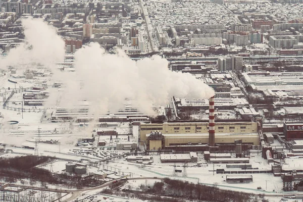 Air pollution by smoke coming out of two factory chimneys. Industrial zone in the city. aerial view. white thick smoke from tall factory pipes. top view of the heating plant.