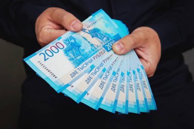 Erkekler ellerini yeni 2.000 Rublesi faturaları bir paket tutmak. 18000 ruble elinde. Yeni iki bin