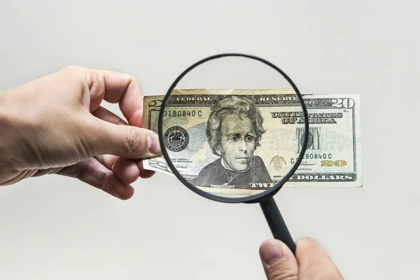 stock image Expert with magnifying glass checks suspicious money. search watermarks on paper of the fake bills. magnifying glass, magnifier, magnifying lens, magnifying glasses, loupe