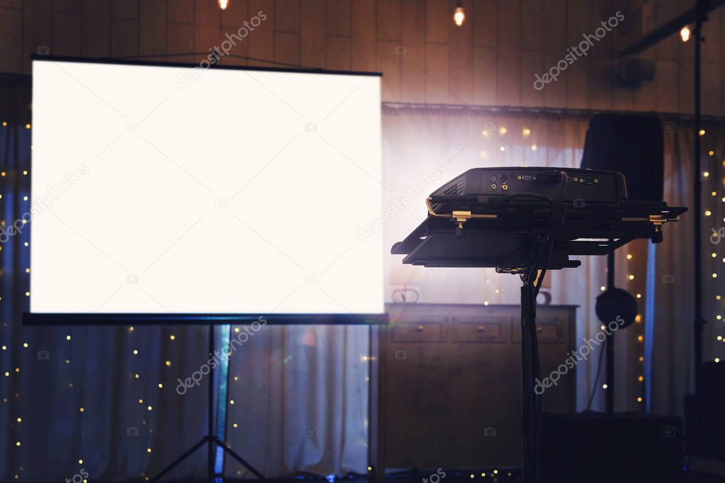 Blank projector screen mockup on the wall. Projection light in darkness. Projector display mock up. Presentation clear monitor on wall. Slide show front design. Slideshow billboard banner frame