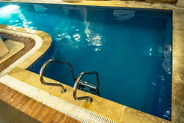 Detail from indoor swimming pool. A small home pool. Swimming pool with blue clear transparent water