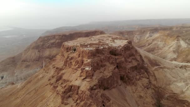 Twierdza Masada obszar południowej dzielnicy Izrael morze martwe strefy południowym, w Izraelu. Starożytnej twierdzy żydowskiej Cesarstwa Rzymskiego na szczycie skały na Pustyni Judzkiej, widok z przodu z powietrza 4 k — Wideo stockowe