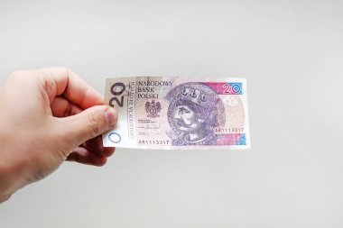 Close up on a 20 zloty banknote in a man's hand. object on white background. clipart