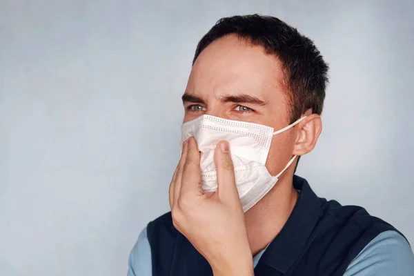 Man closes his mouth and nose from bad smell or stinky gas bad ecology. The concept of gas contamination and dust. harm to health, health damage, damage to health .Quarantine patient