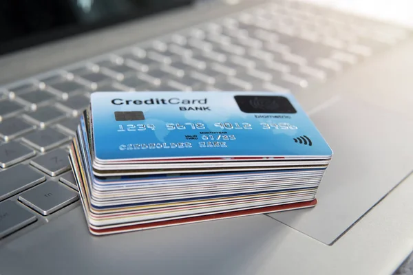 Pile of plastic credit cards on the laptop keyboard. Open access for online shopping using biometric card. Payment cards with finger sensor on the surface. Payment system of new generation. Stack.