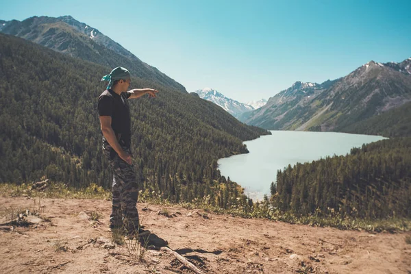 Un hombre mirando río desde el mirador a lo largo del sendero a los Lagos Azules. Un hombre de uniforme señala el camino al lago. Concepto de Senderismo y Viajes — Foto de Stock