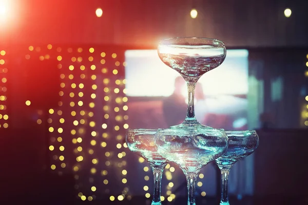 Los niveles superiores de la torre de champán en el fondo de la pantalla de iluminación y proyector de la sala de banquetes de boda. Hermoso conjunto de copas coupé en el fondo de proyección pareja amorosa. Boda de lujo . — Foto de Stock