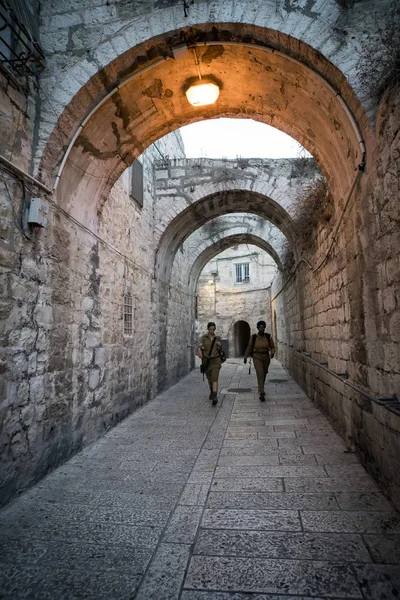 Mulheres brancas e negras de uniforme militar andando na rua estreita da cidade velha de Jerusalém. Jerusalém, Israel: 24 de outubro de 2018 — Fotografia de Stock